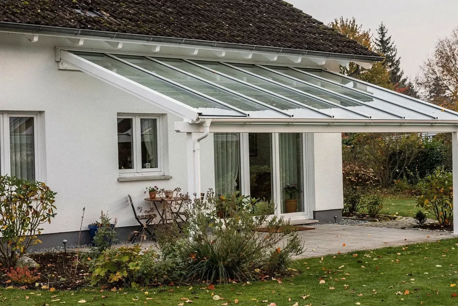 Moderne Terrassenüberdachung mit Glasdach an einem Einfamilienhaus in Erlangen